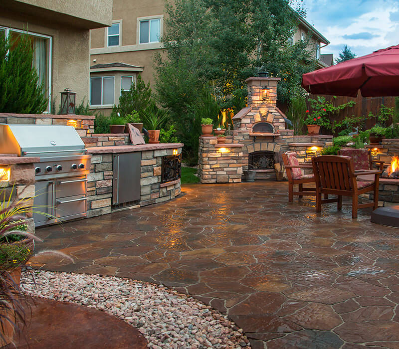 hardscape patio with outdoor kitchen and fireplace