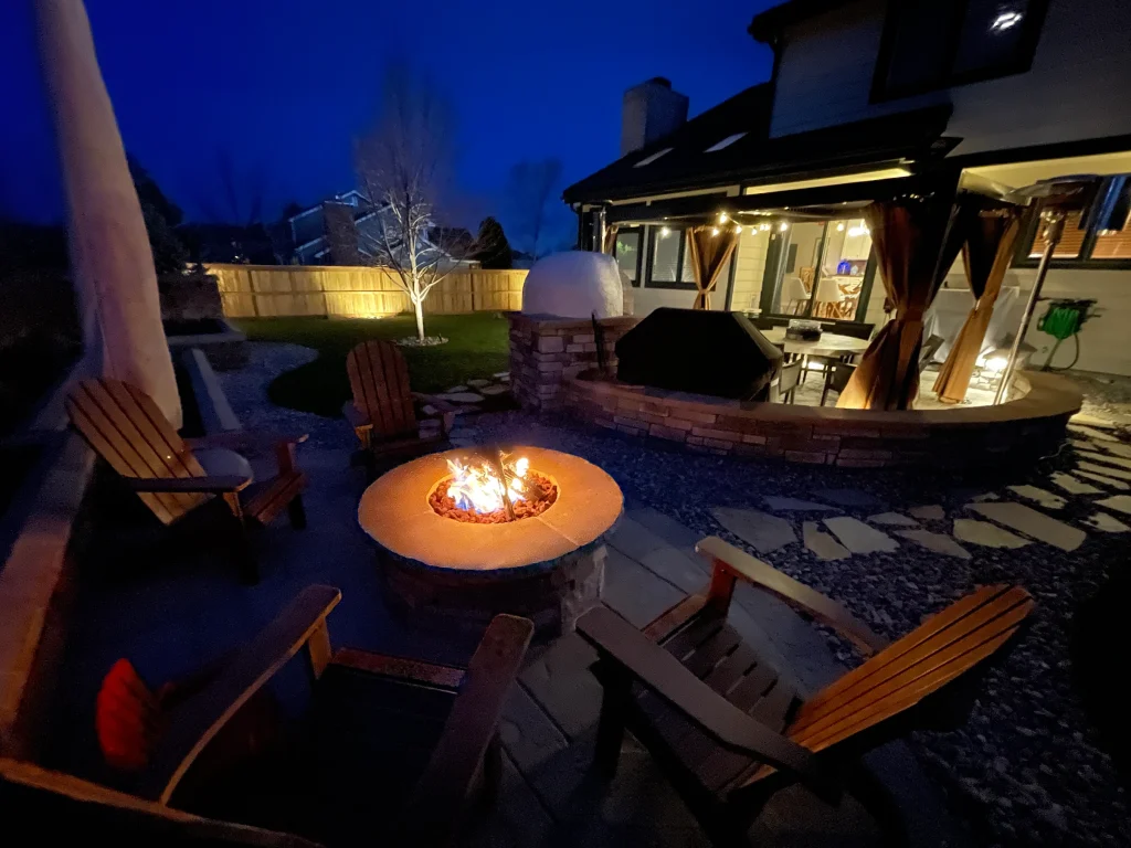 Fully equipped custom outdoor kitchen and stone fire pit on a Belgard paver patio in Highlands Ranch