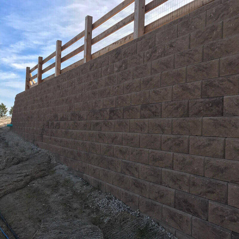 Structurally engineered modular block retaining wall managing a sloping hill in Castle Rock